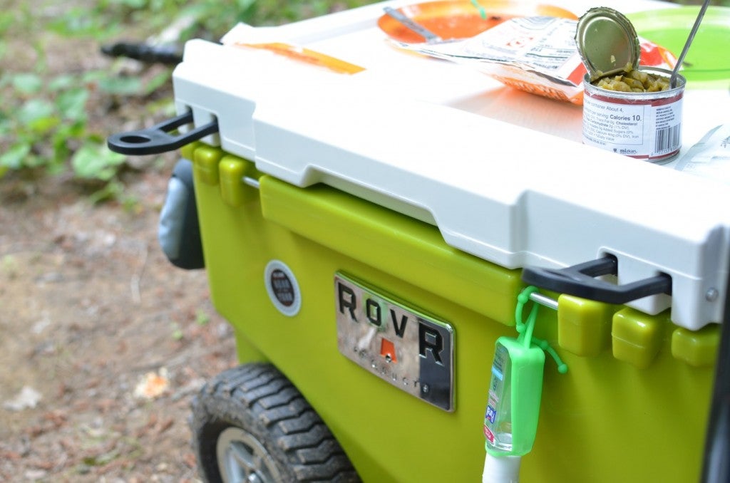 a rovr cooler with food on top and hand gel attached
