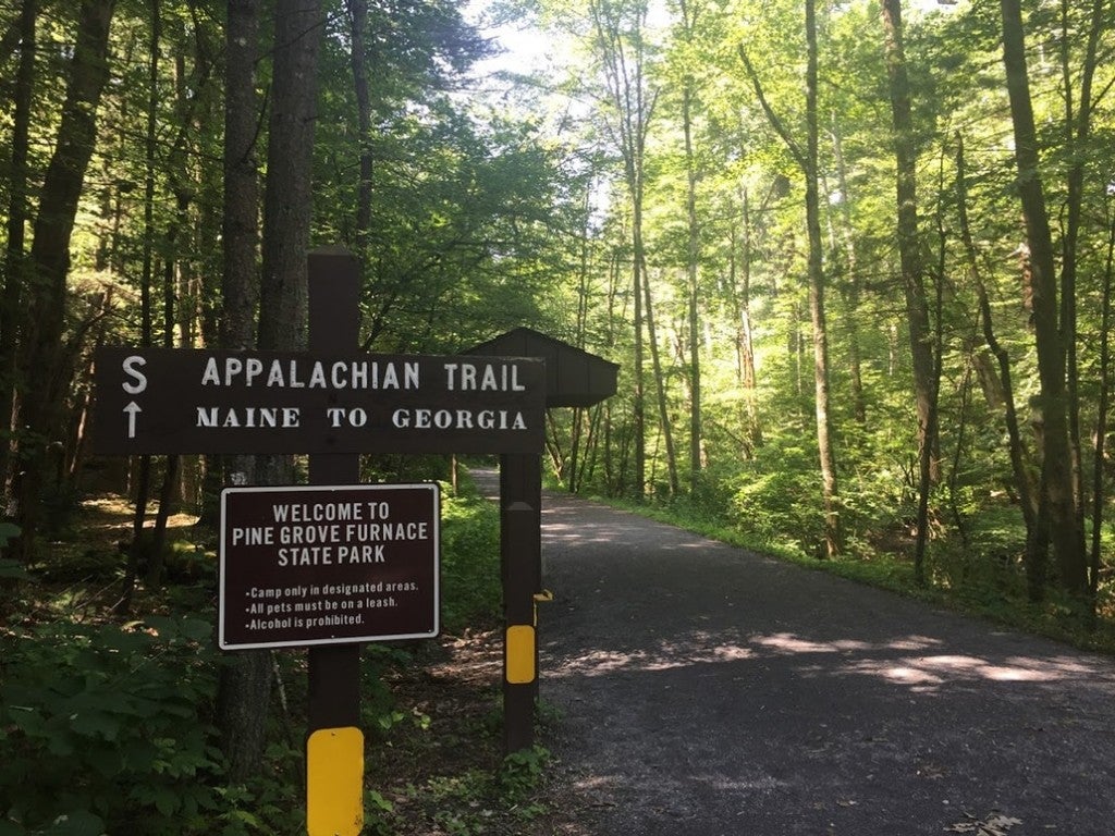 a wooden sign on the PA appalachian trail pointing at maine and georgia