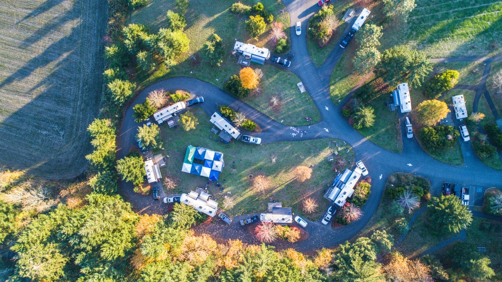 an ariel view of a campground loop with buildings, tents and RVs