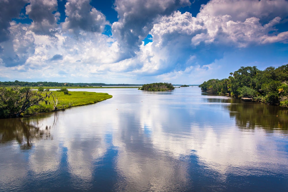 reflections of clouds on the tomoka river in tomoka state park in florida