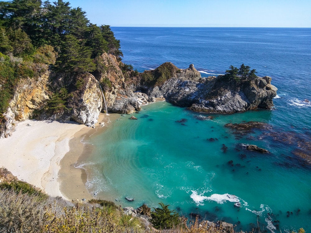 a tide pool with a waterfall into the ocean