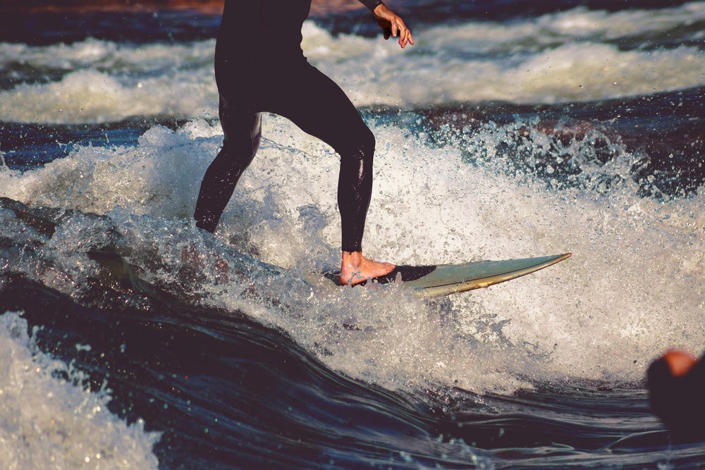 Surfer riding a breaking wave in a river.