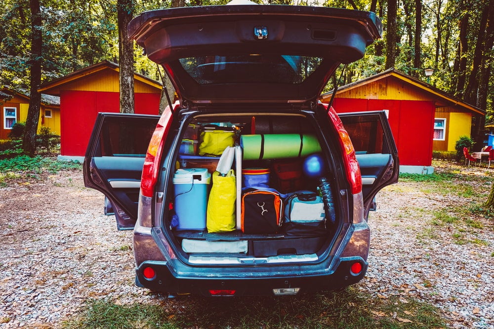 a van packed with camping gear at a campsite