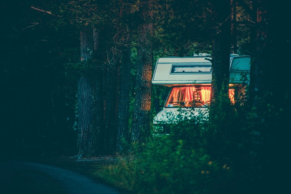 an RV nestled into the forest while boondocking at night