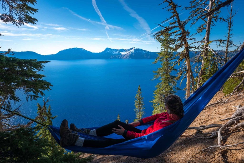 a woman resting in a hammock over crater lake in oregon