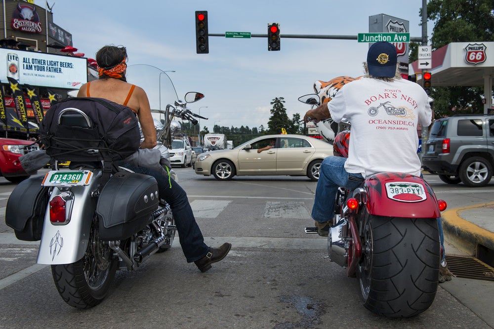 Man and woman on motorcycles waiting at stoplight at Sturgis Motorcycle Rally