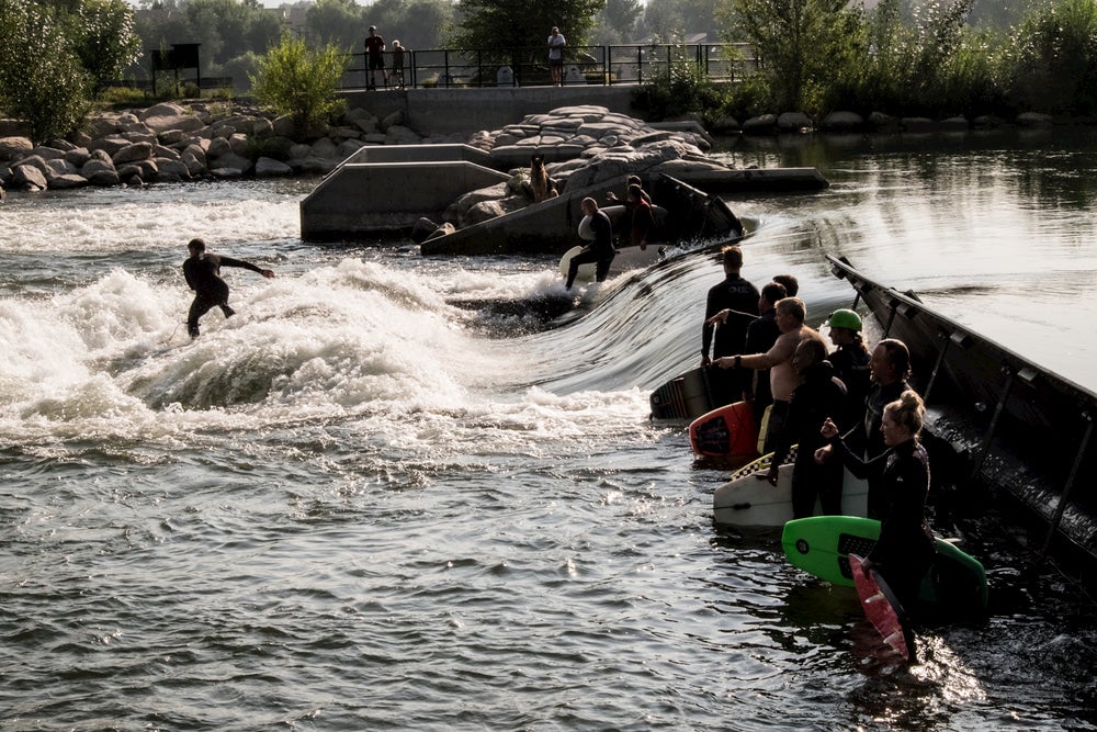 Group of surfers riding a wave in a river in Idaho