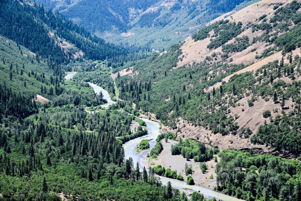 Klickitat River winding through valley surrounded by evergreens.