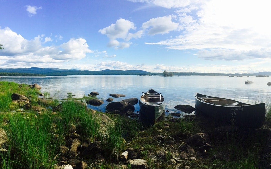 Panoramic view of a lake and canoes