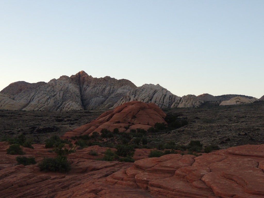 a red rock field with mountains in the distance in utah