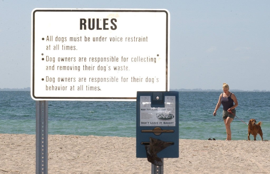 a sign at a dog park on the beach