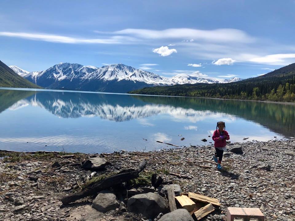 a young child walking along a lake