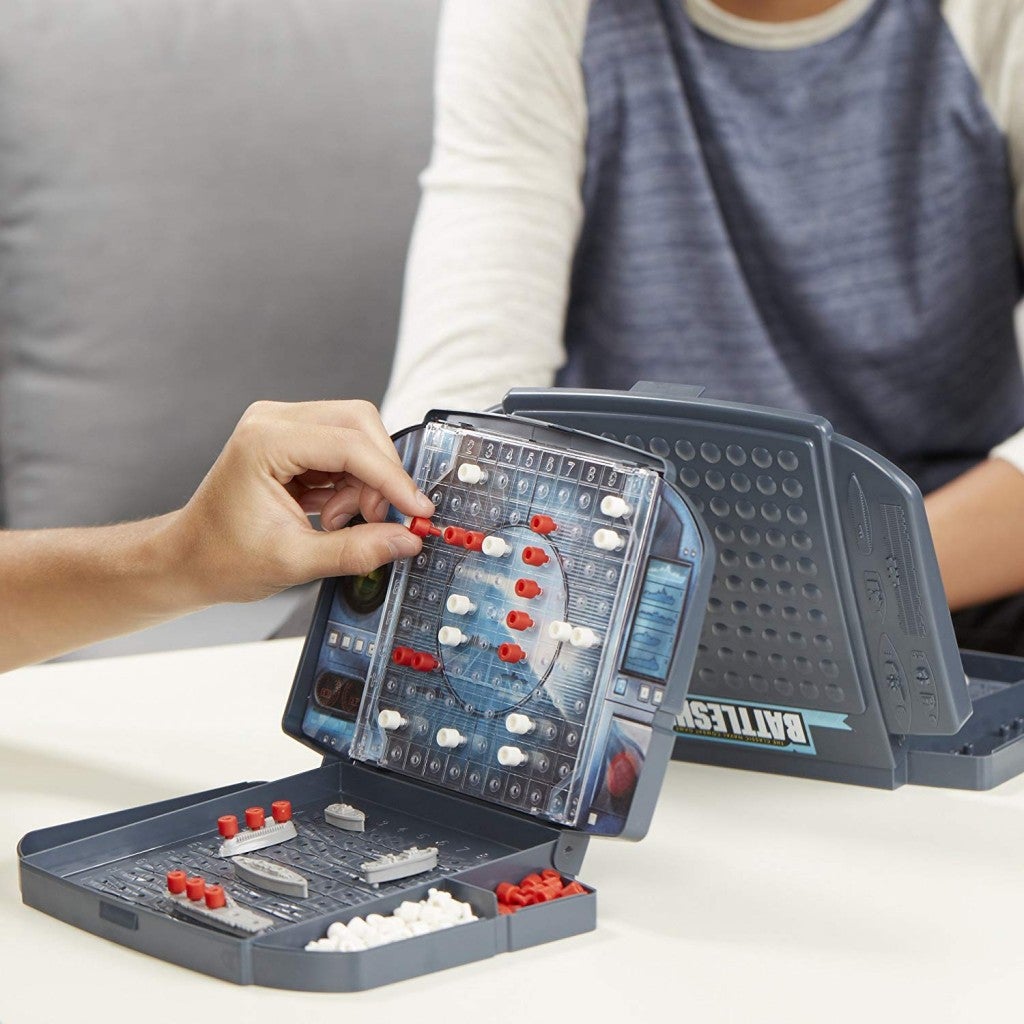 two people playing battleship board game on a table