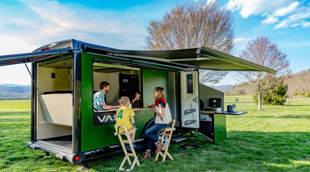 family members hang out at the bar on the side of their vast camper