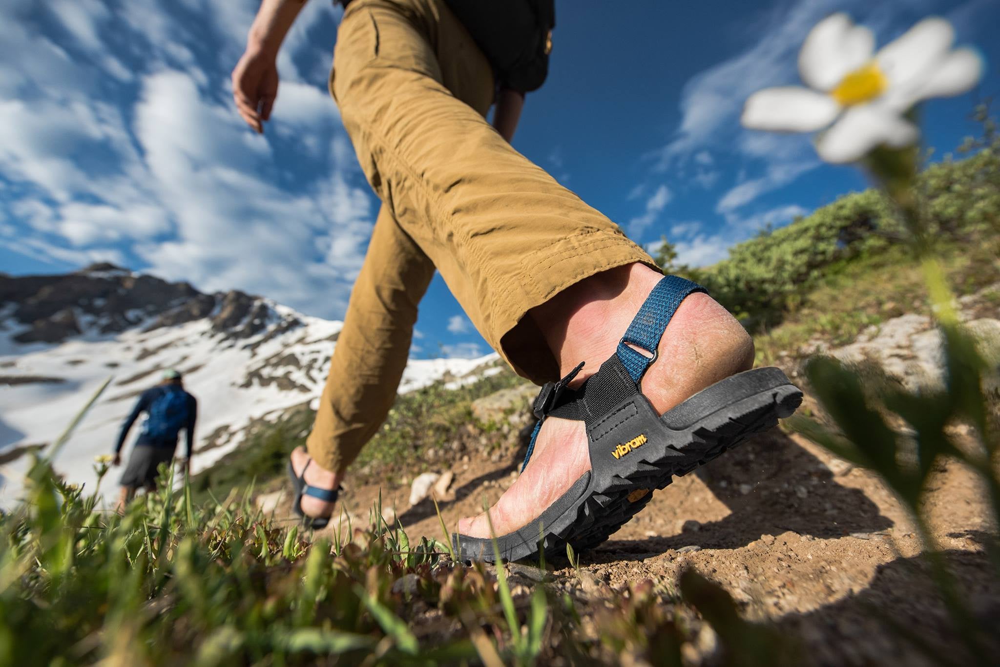 a person walks on a trail in a pair of bedrock hiking sandals