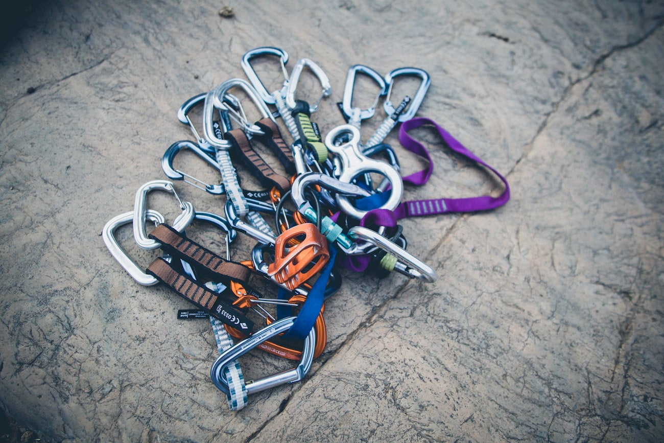 Loop of webbing holding sets of quickdraw carabiners.