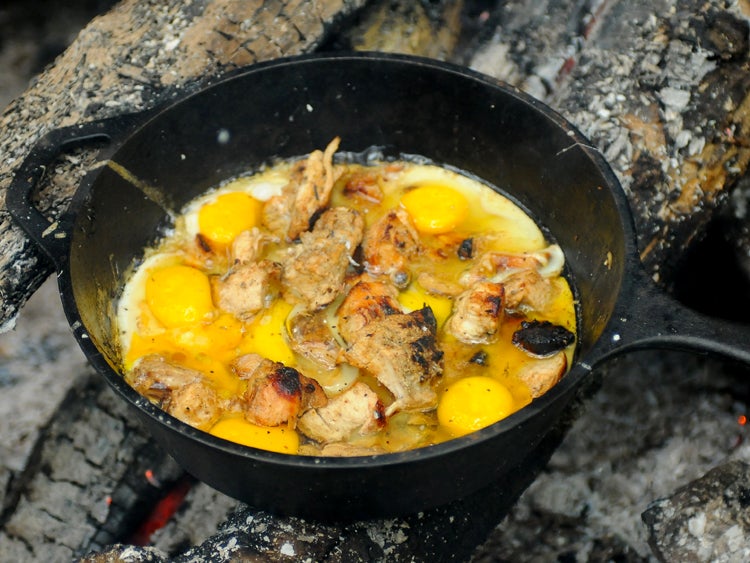eggy scramble in cast iron skillet over campfire
