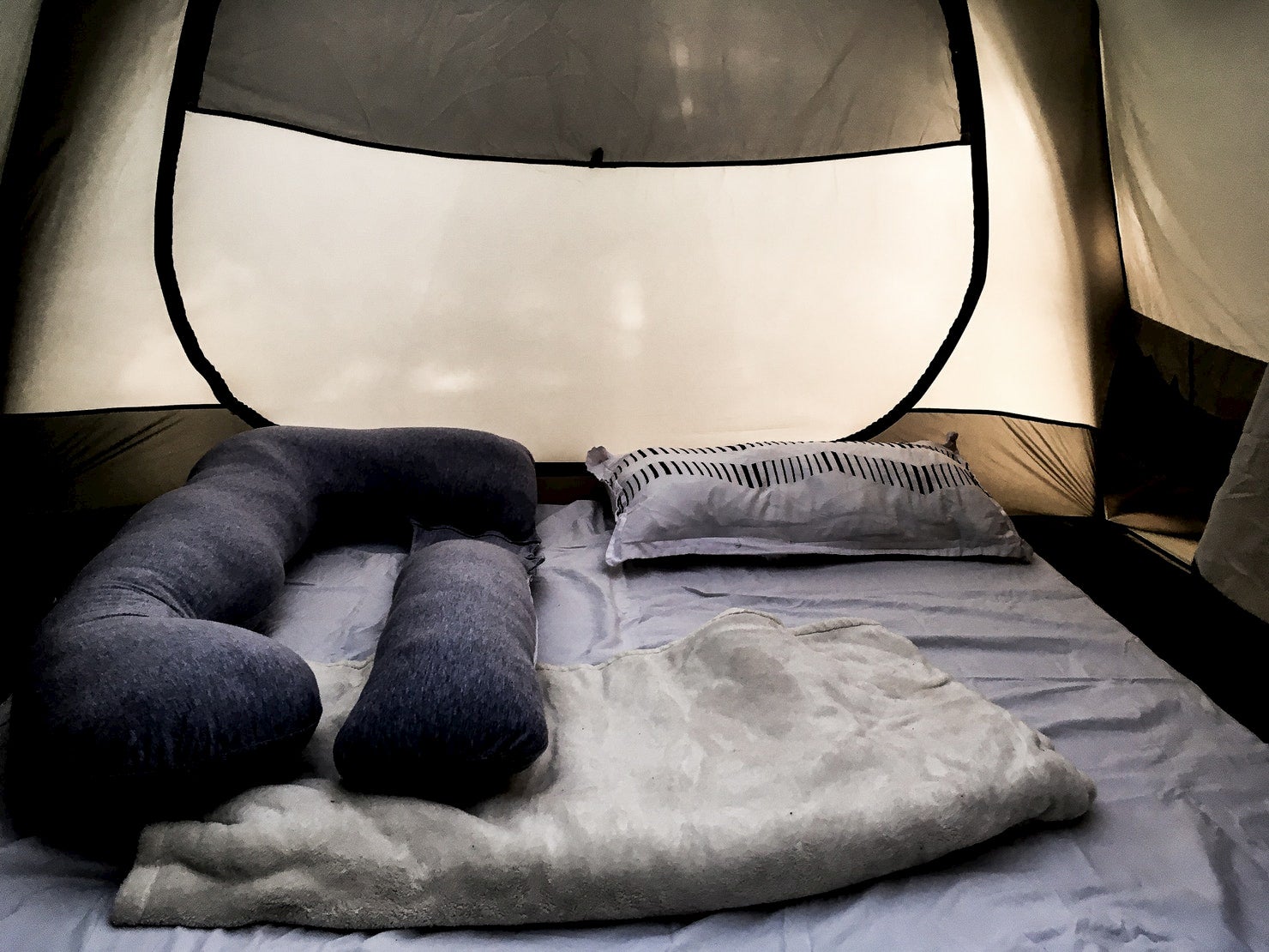 Pregnancy pillow and cozy mat in tent.