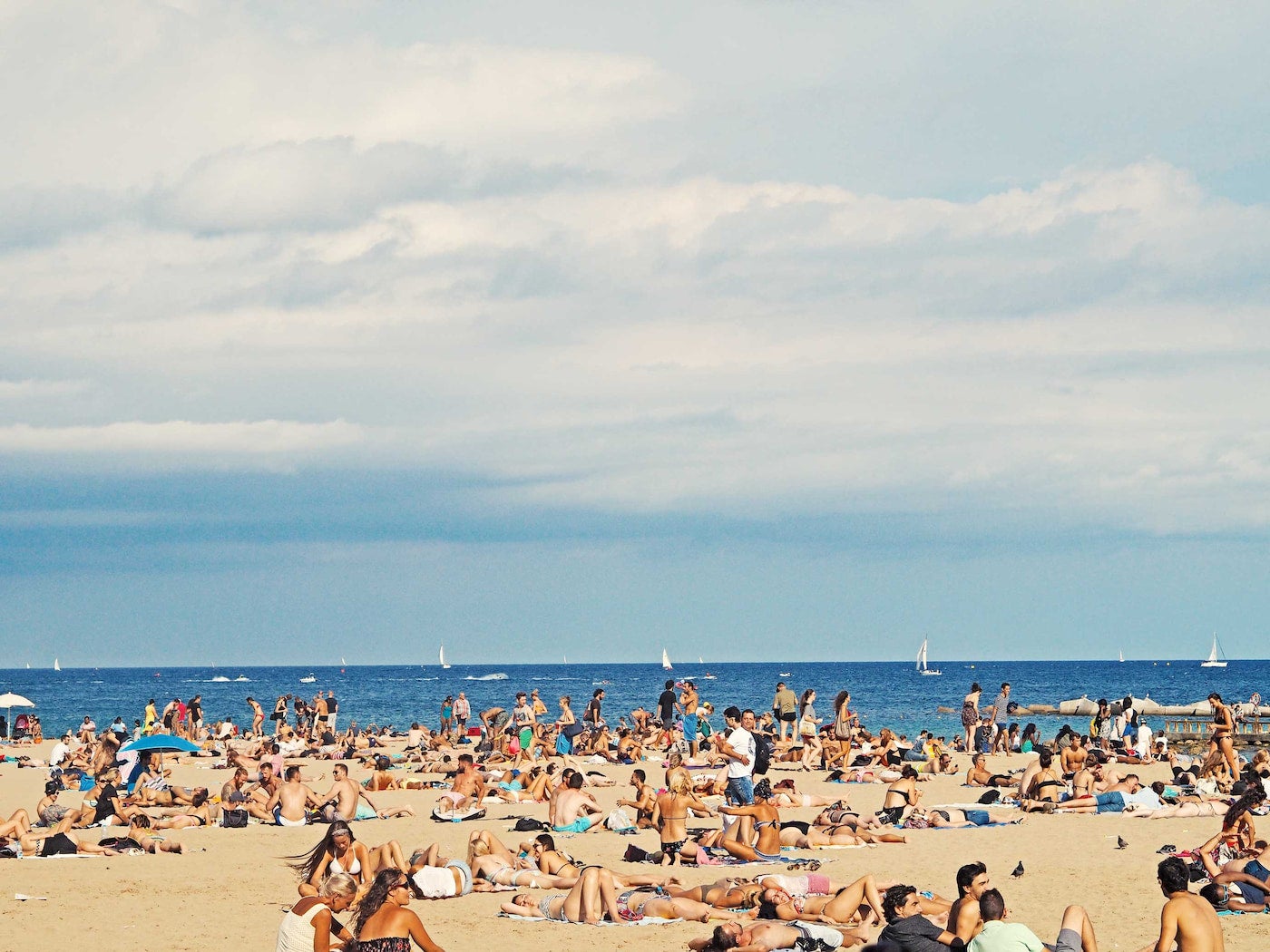 Crowd sunbathing on the beach.