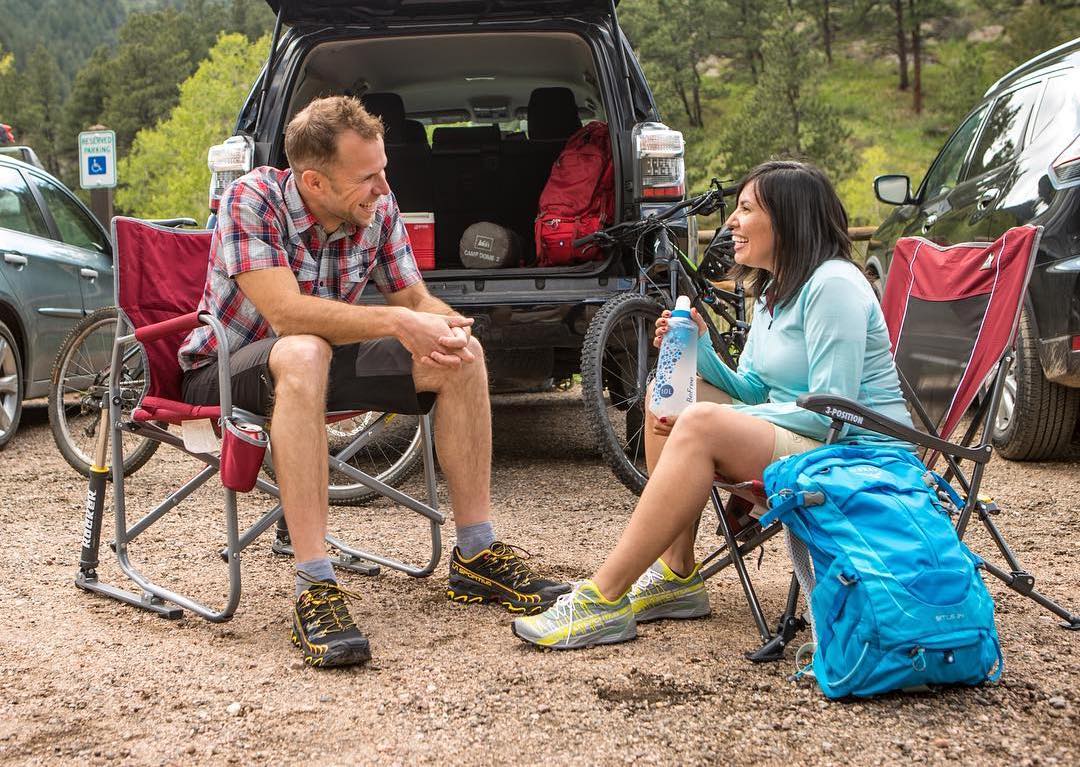 Two people sitting in GCI camp chairs.