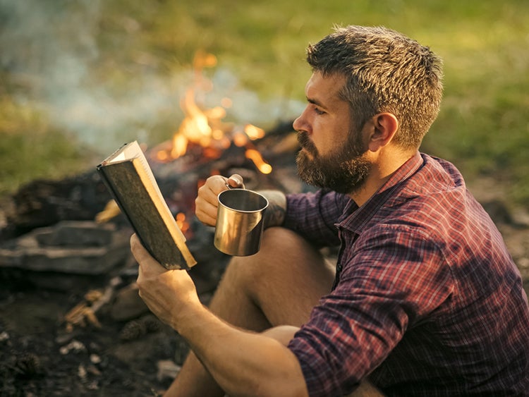 reading in camp with campfire