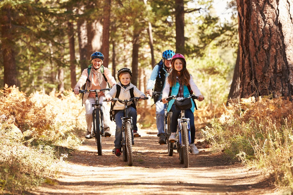 two kids and grandparents riding bikes along a trail