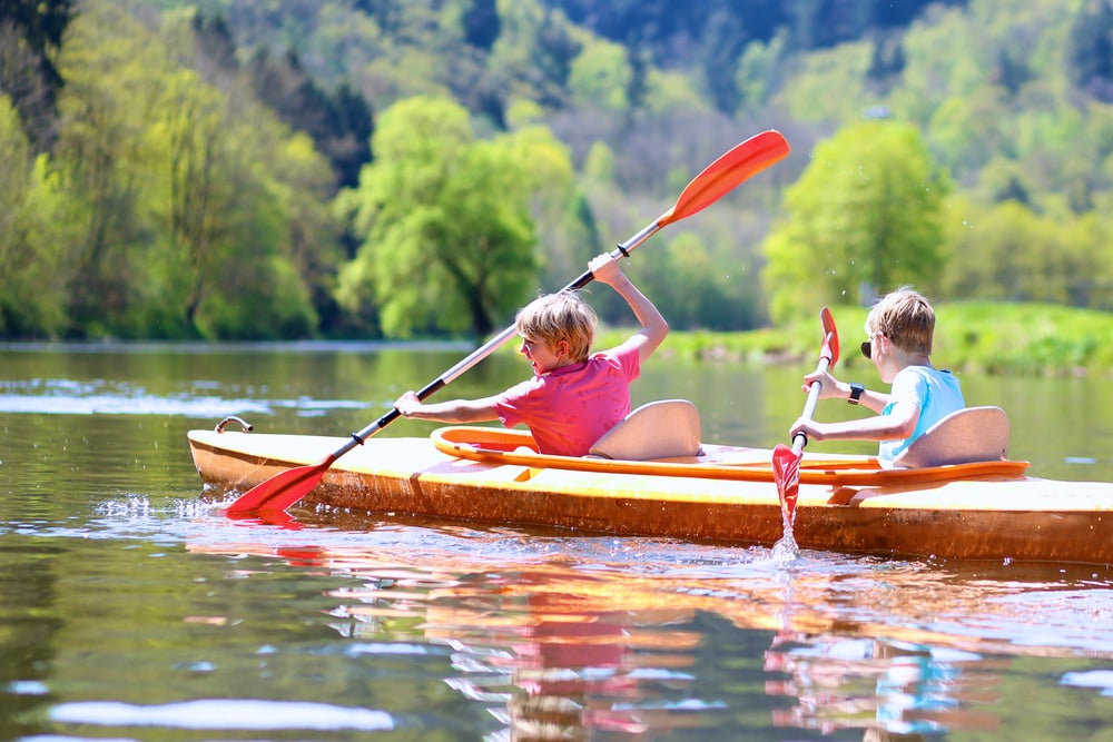 two children in a kayak on a river