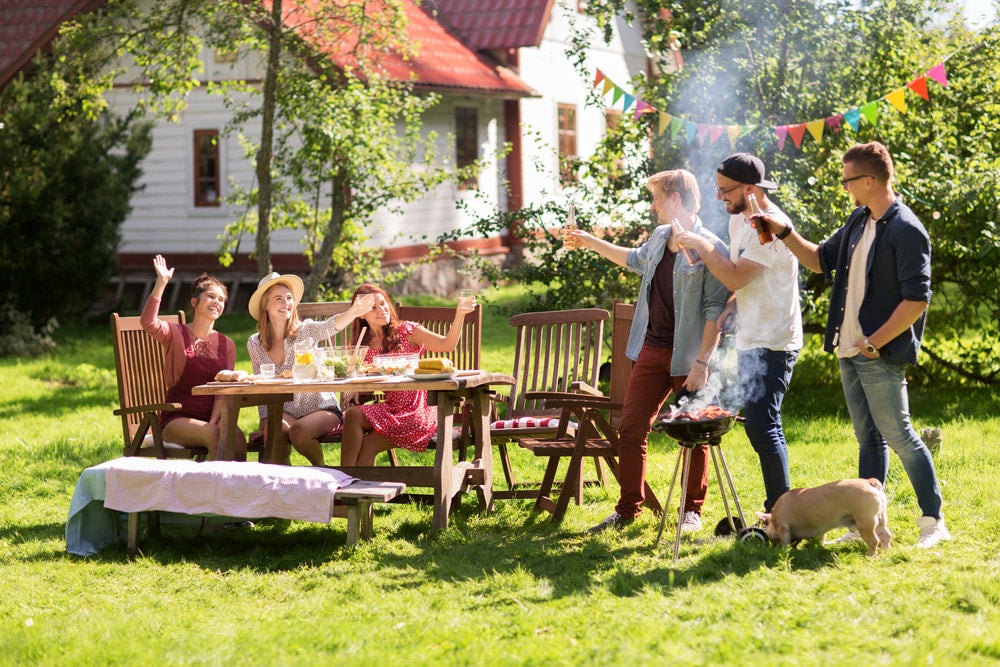 Group of friends having a BBQ in backyard 