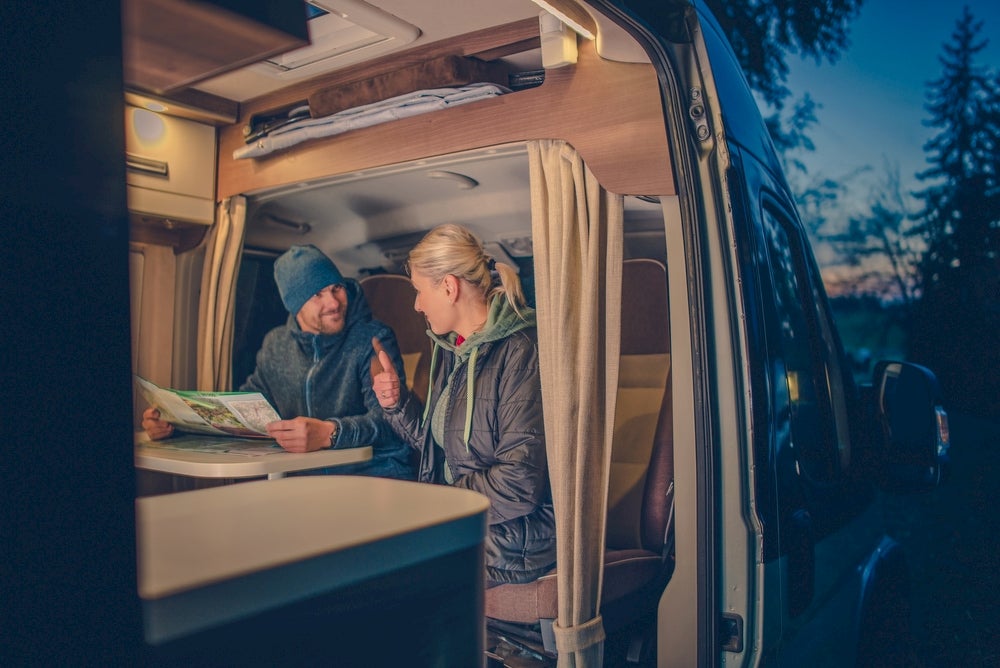 Two people in RV looking at a map