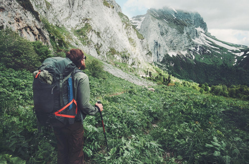 Man looking at mountains wearing backpack 