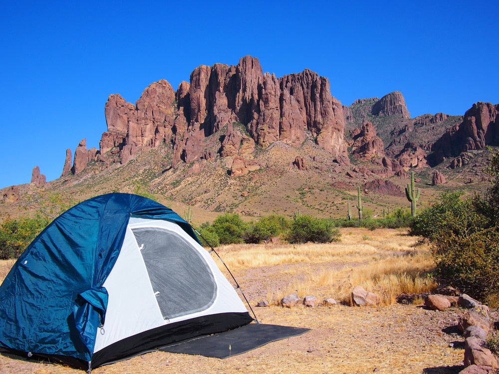 Tent in foreground with red rock formation in background