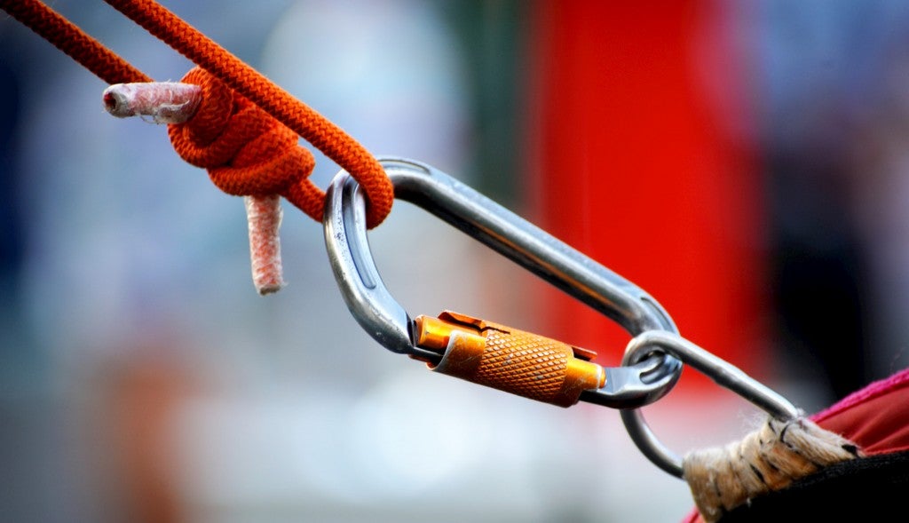 Locking carabiner between a rope and a metal loop.