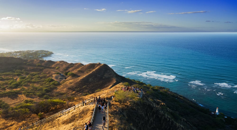 crowds of hikers walk up diamond head volcanic monument near honolulu, hawaii