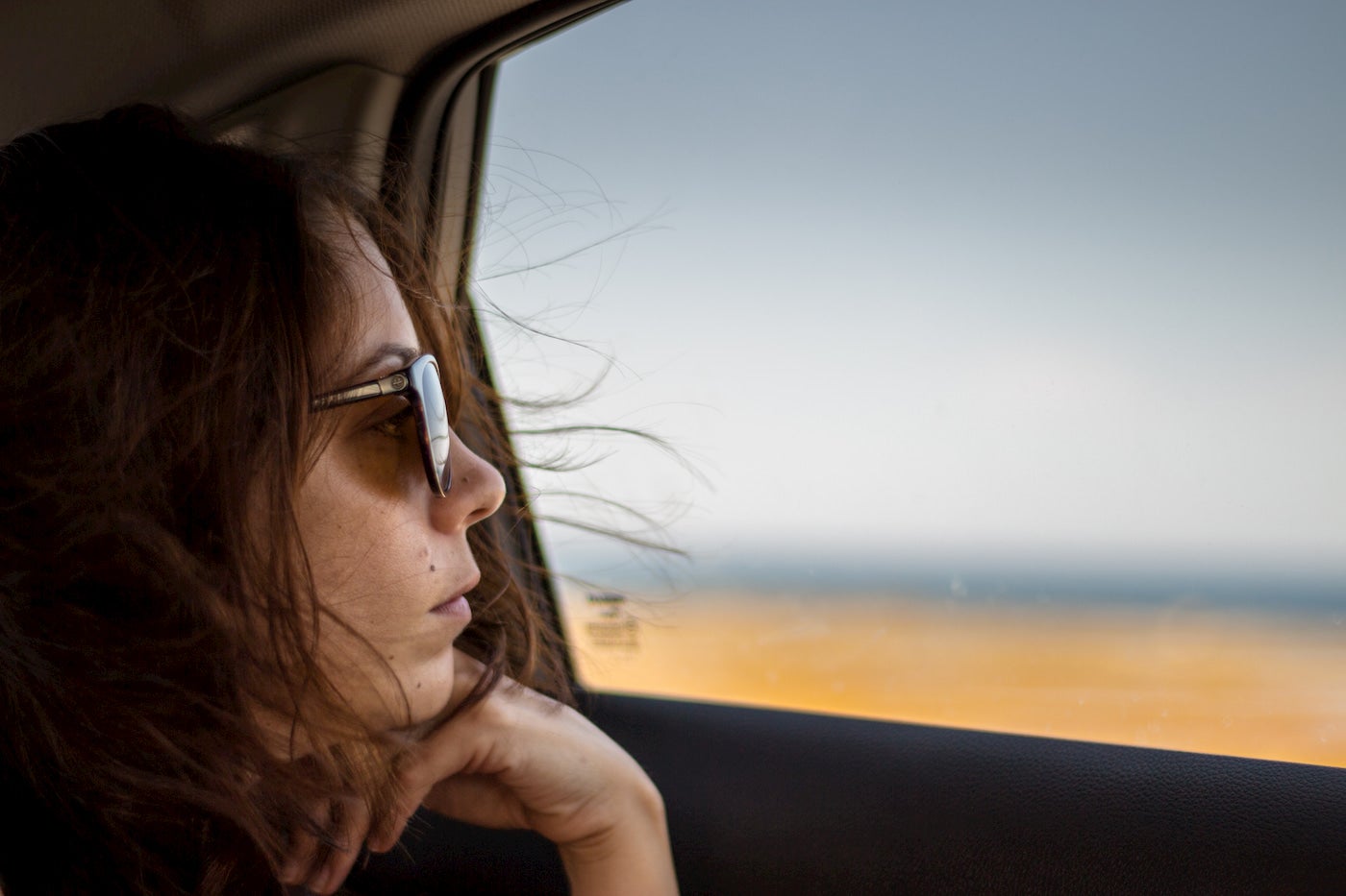 Women wearing sunglasses while looking out the window.