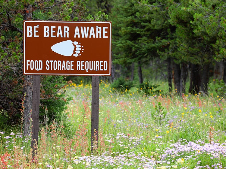 bear aware food storage sign on a trail