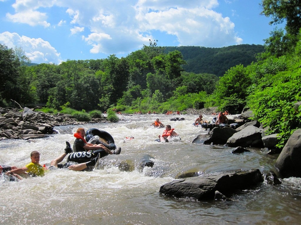 many people flying down river rapids in tubes in new york