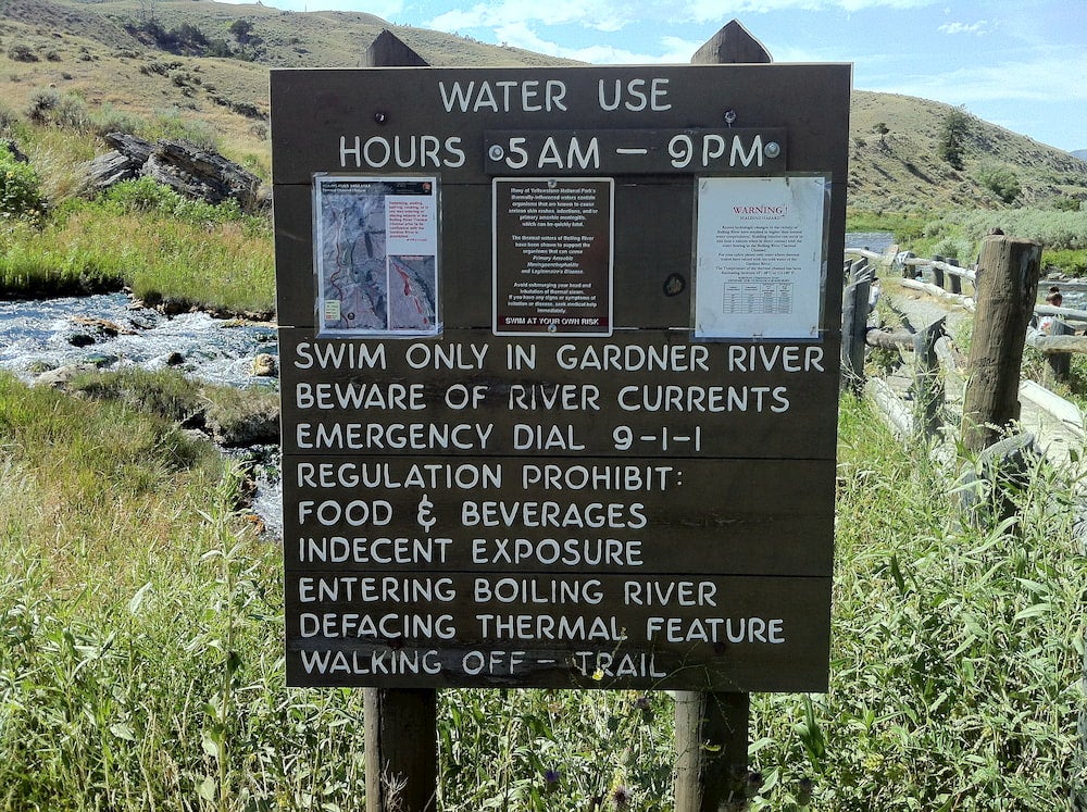 a wooden sign listing info and rules for the boiling river in wyoming