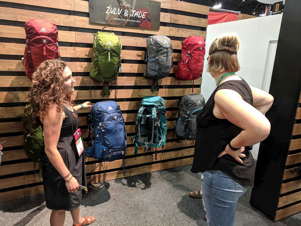 two women looking at backpacks at outdoor retailer 2019