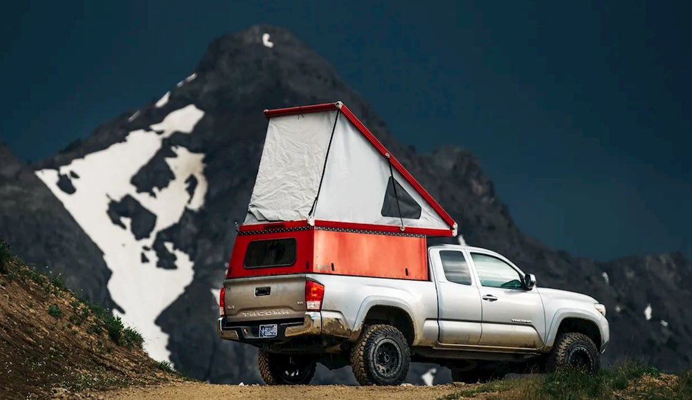 Truck with rooftop tent and mountains in background 