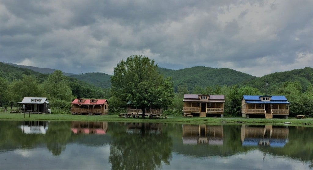 four wood cabins on a lake in the mountains
