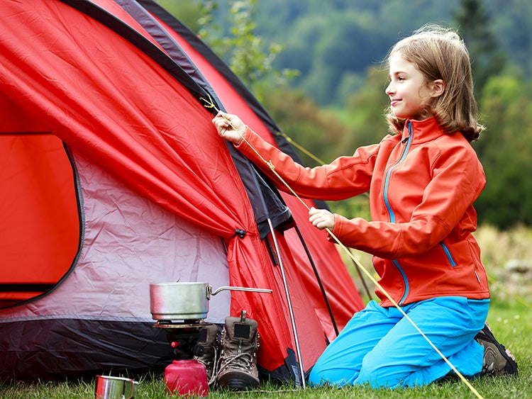 young girl setting up tent camp