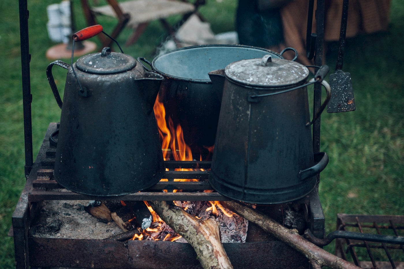 Kettles and pot cooking over a fire.