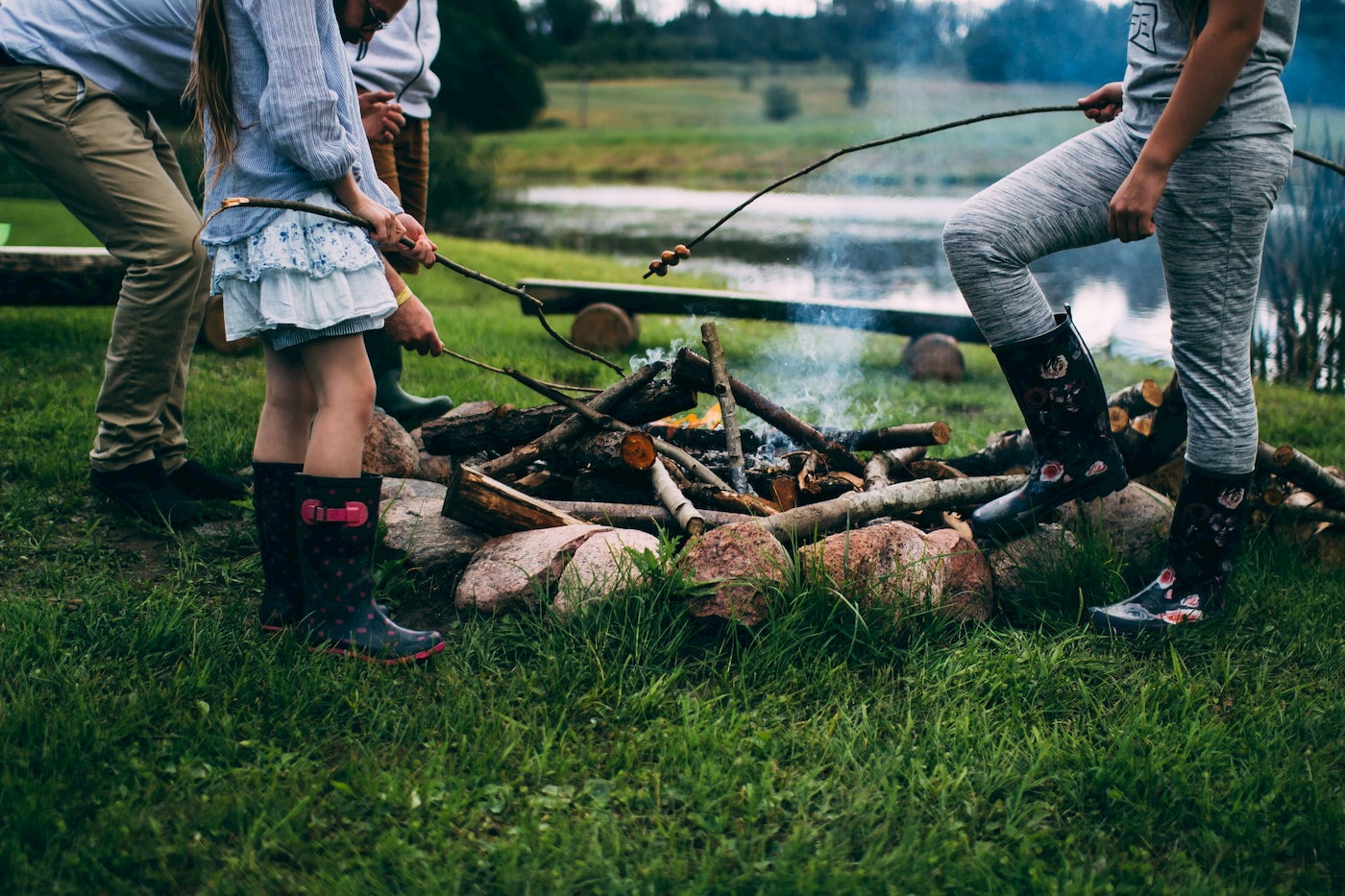 Family roasting s'mores around the fire.