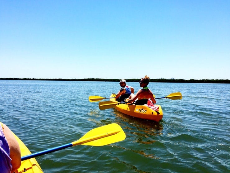 two kayakers in yellow boat look back at photographer on waters near Fort Desoto County Park, photo from a camper on The Dyrt