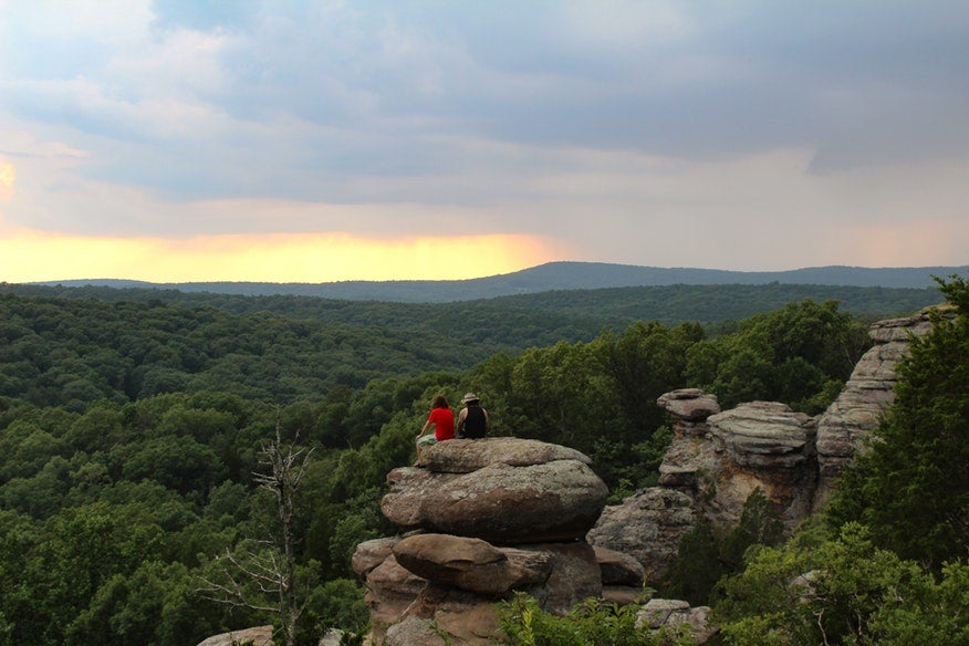 two hikers rest on boulder overlooking Illinois' Garden of the Gods at sunset, photo from a camper on The Dyrt