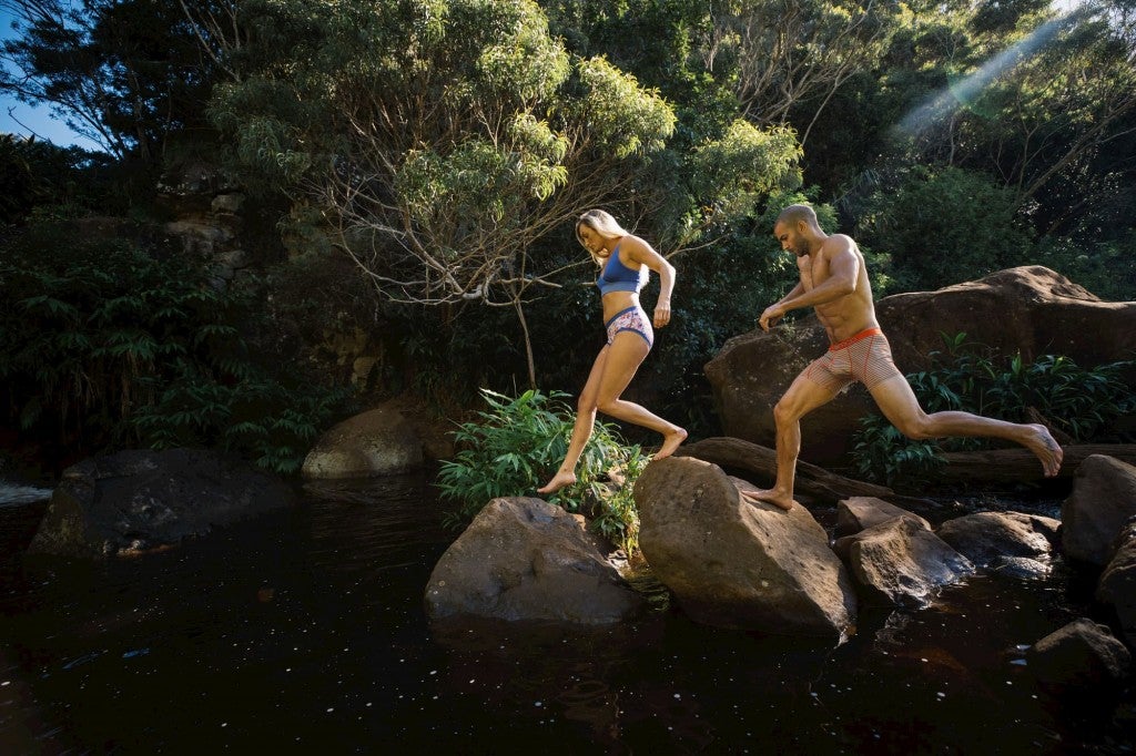 two hikers run on a trail in underwear