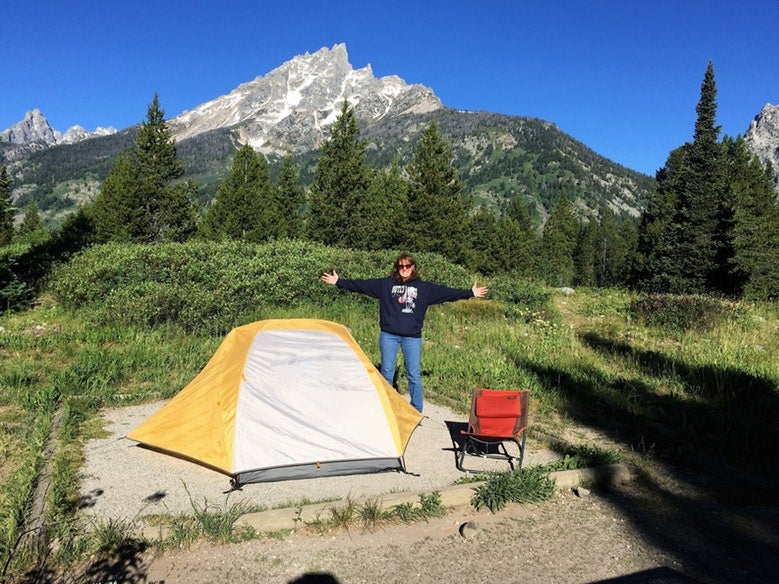 woman poses for photo with arms outstretched at Jenny Lake Campground in wyoming, photo from a camper on The Dyrt