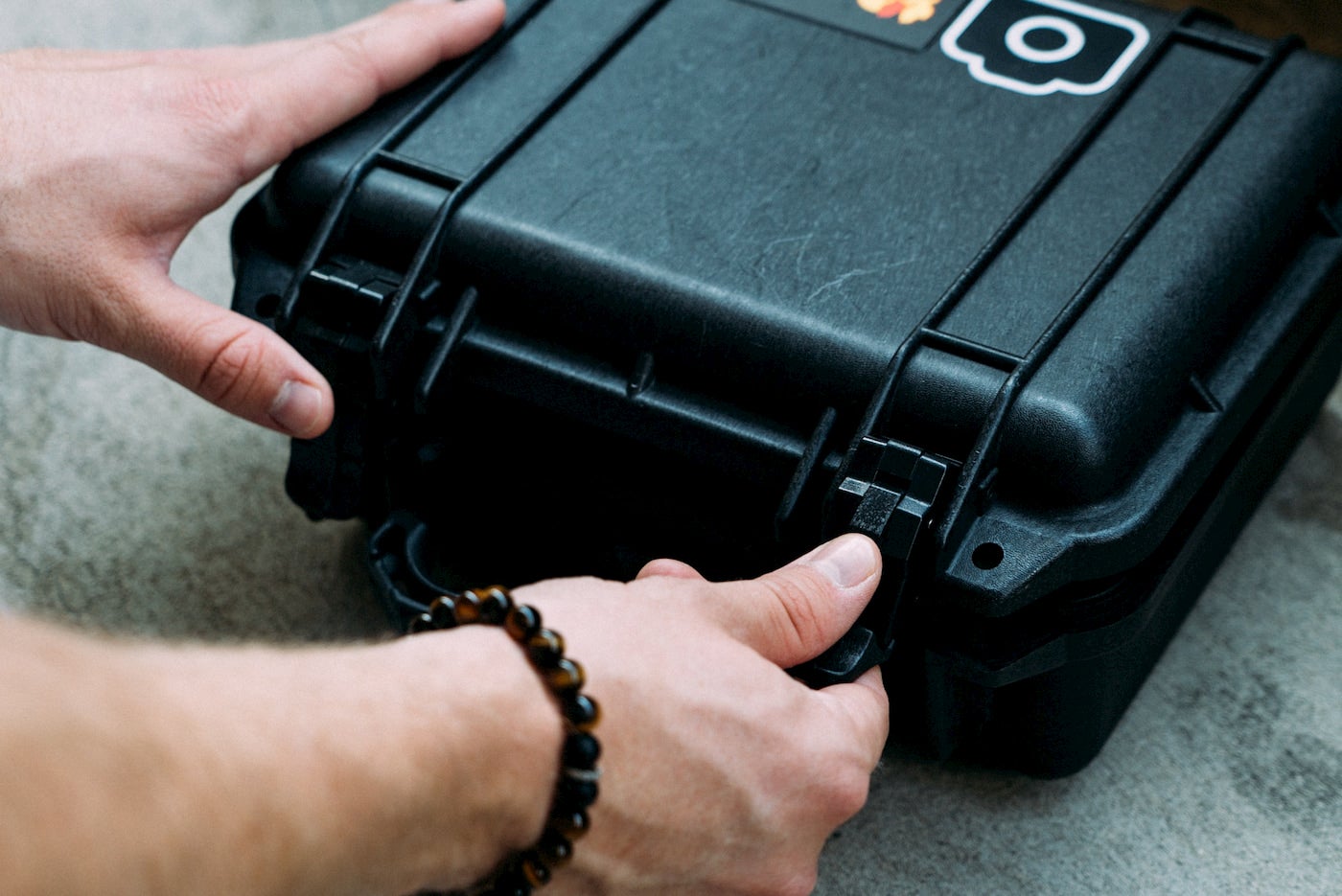 Person opening a small pelican case.