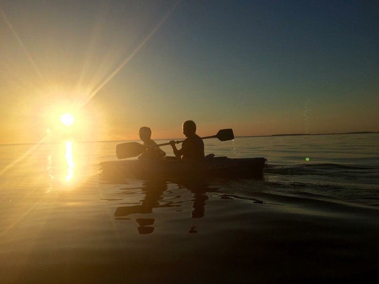 silhouette of kayakers on calm waters in Michigan's Wilderness State Park, photo from a camper on The Dyrt