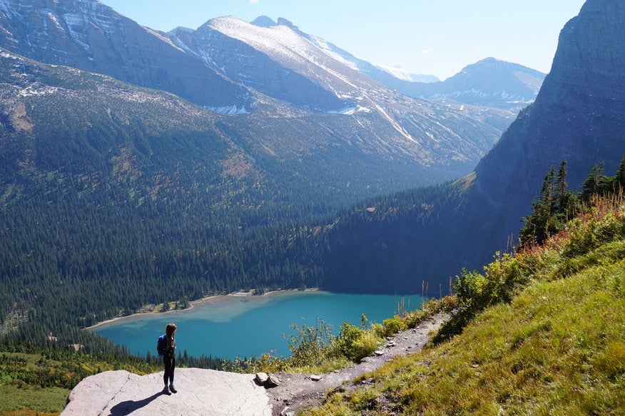 hiker stands on boulder overlooking lake near Many Glacier campground, photo from a camper on The Dyrt